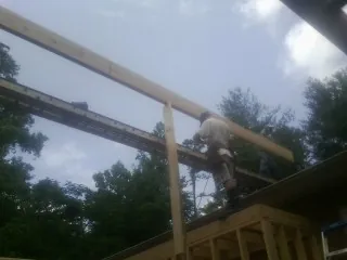 Carpenter setting a ridge beam over a new addition frame — Ice Dam Removal by Roofing Brothers in Capitol Heights