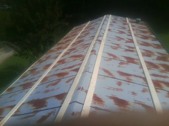 Rusted metal roof panels with new wood purlins before replacement — Storm Damage Roof Repair in Capitol Heights by Roofing Brothers