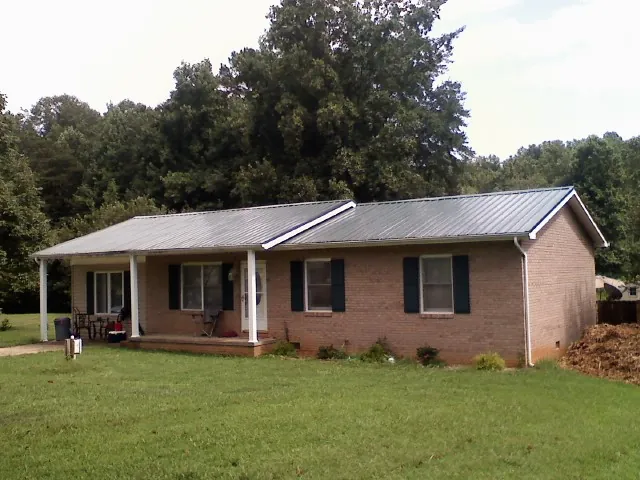 Gray metal roof on a brick ranch house with a side carport in Capitol Heights