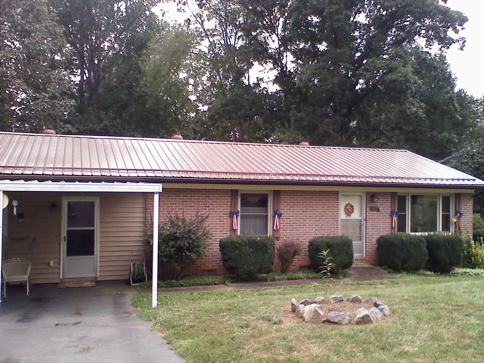 Bronze metal roof and carport on a brick ranch home — Roof Repair work by our crew in Capitol Heights
